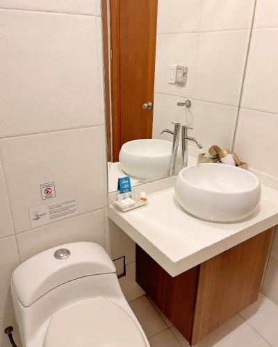 a bathroom with a white toilet and a sink at Hotel Fundador by Robles in Arequipa