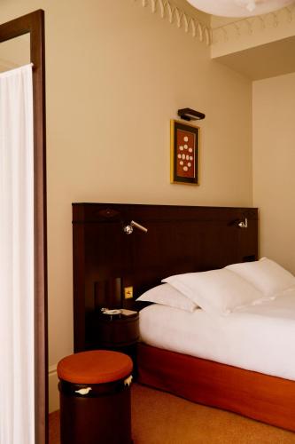 a hotel room with a bed and a stool at Grand Hotel Bellevue London in London