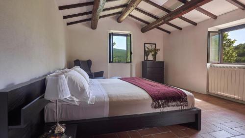 um quarto com uma cama e duas janelas em La Mita em Cortona