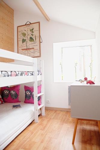 une chambre avec deux lits superposés et un bureau dans l'établissement Le gîte des Algues, à Séné