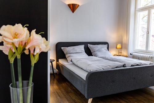 um quarto com uma cama e um vaso com flores em Elbpanorama Lauenburg em Hohnstorf