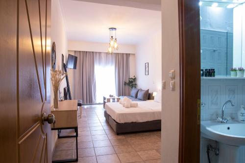 a bedroom with a bed and a bathroom with a sink at Olymp-rooms in Litochoro