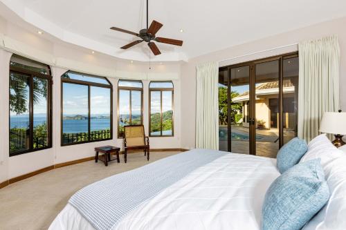 una camera con un grande letto e ampie finestre di Casa Pom Pom a Playa Hermosa