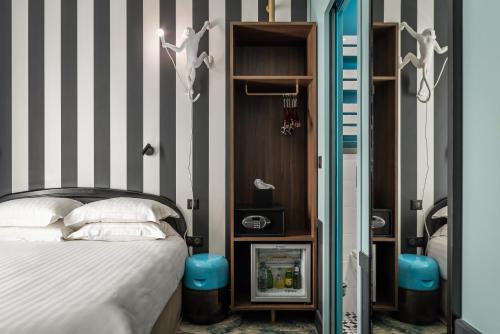a bedroom with a bed and a striped wall at Hotel Archetype Etoile in Paris