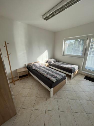 two beds in a room with two windows at Ubytování Pardubice Trnová in Pardubice