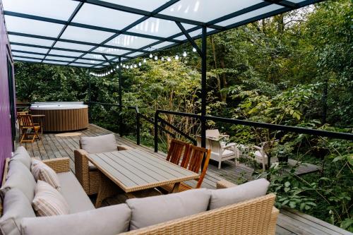 une terrasse avec des canapés, une table et des chaises dans l'établissement Gipsy Village Park Hotel, à Asuretʼi
