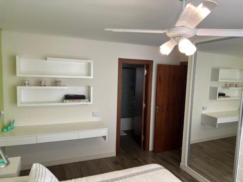 een kamer met witte planken en een plafondventilator bij Alucinante departamento en La Perla 3 ambientes con aire acondicionado y calefacción central in Mar del Plata