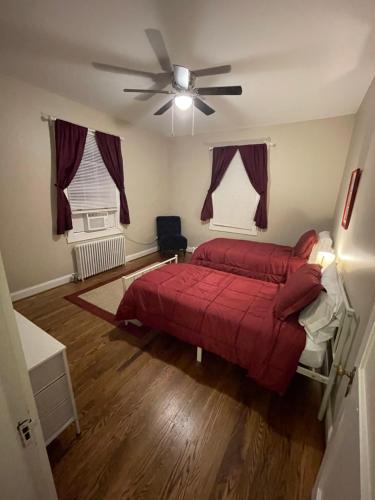 a bedroom with a red bed and a ceiling fan at Lynchburg Leisure in Lynchburg