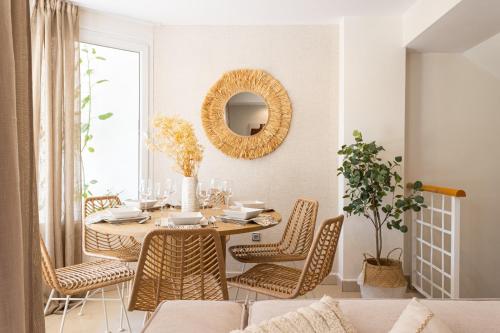una sala da pranzo con tavolo, sedie e specchio di Sunny Home a Benalmádena