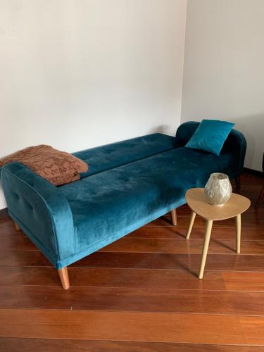 um sofá azul numa sala de estar com uma mesa em Suite de lujo Quito em Quito