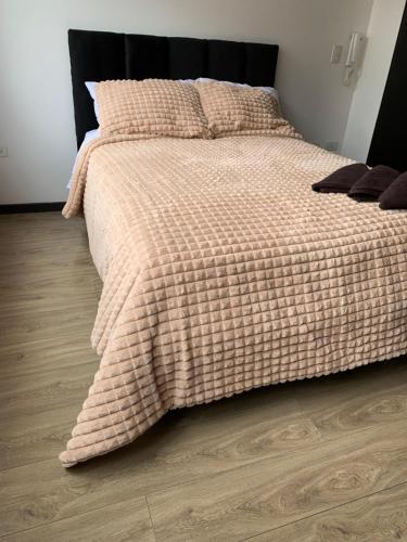 um quarto com uma cama com um cobertor xadrez em Suite de lujo Quito em Quito