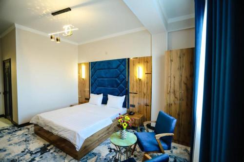 1 dormitorio con 1 cama, mesa y sillas en Almaty City en Türkistan