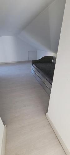um quarto branco com uma cama no meio em Appartement 15km Futuroscope em Saint-Julien-lʼArs