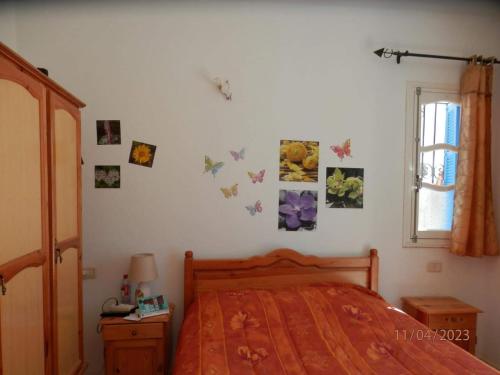 a bedroom with a bed with butterflies on the wall at Villa Amine MG in Fafou