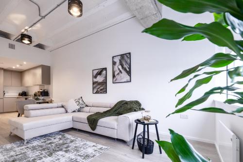 a living room with a white couch and a table at Station House in Milton Keynes