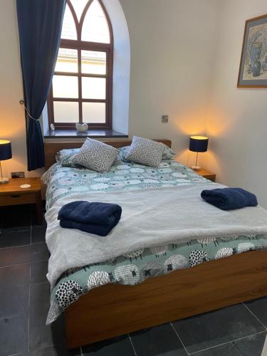 a bedroom with a bed with blue pillows on it at Converted chapel - Sant Pedr Newydd - with sea views in Amlwch