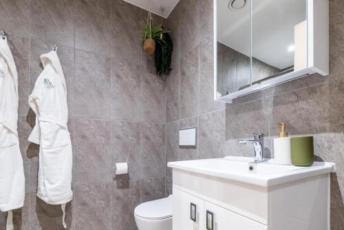 bagno con lavandino, servizi igienici e specchio di Elegant central apartment a Milton Keynes