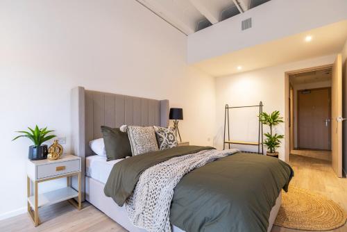 una camera con un grande letto e un comodino con comodino di Elegant central apartment a Milton Keynes