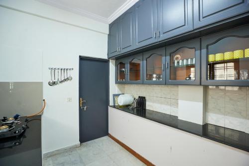 een keuken met blauwe kasten en een aanrecht bij Stylish 1.5 BHK A/C at BanjaraHills Near CareHospitals in Hyderabad