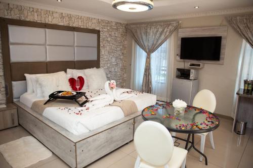 um quarto com uma cama grande, uma mesa e cadeiras em Boeketlong Lodge em Jane Furse