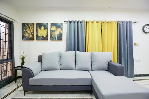 sala de estar con sofá y algunas cortinas en Stylish 1.5 BHK A/C at BanjaraHills Near CareHospitals en Hyderabad