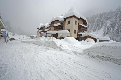 a building covered in snow on a snow covered road at Stelvio Residence in Trafoi
