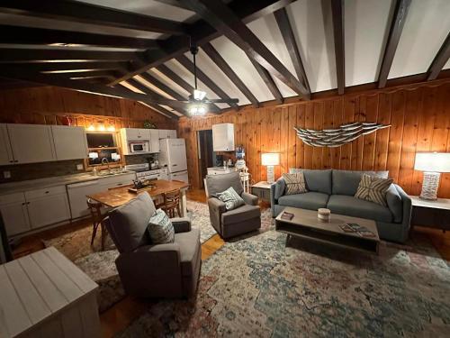 South Shore Resort - The Sparrow في Twin Lake: غرفة معيشة مع أريكة وكراسي ومطبخ