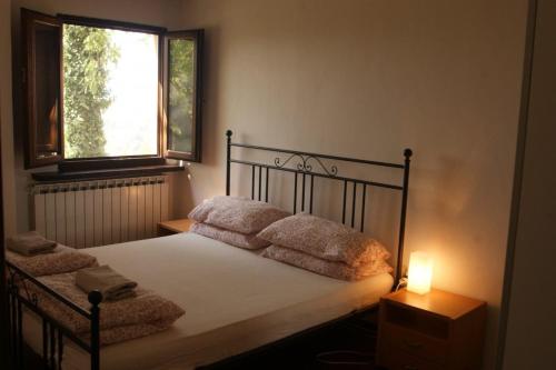 een slaapkamer met een bed met kussens en een raam bij Camping Le Marche Apartments in Gualdo di Macerata