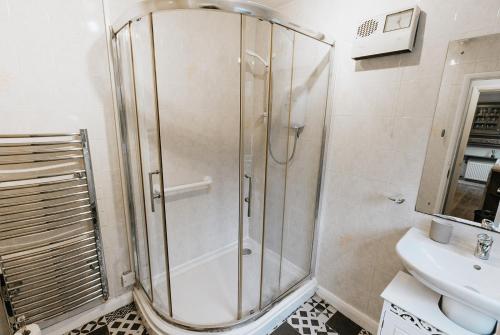 a bathroom with a shower and a sink at Winnie's Cottage - 3 Bed Accommodation in Cumbria in Mealsgate