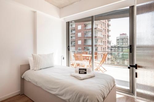 a bedroom with a bed and a large window at Top Rentals Deheza in Buenos Aires