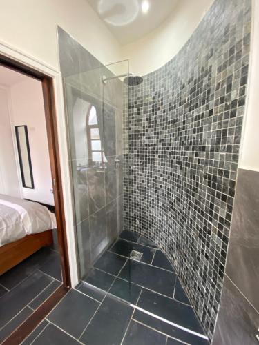 a bathroom with a shower with a glass door at Converted chapel - Sant Pedr Newydd - with sea views in Amlwch