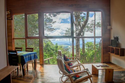 a room with a table and chairs and a large window at Casa Por Fin in Monteverde Costa Rica