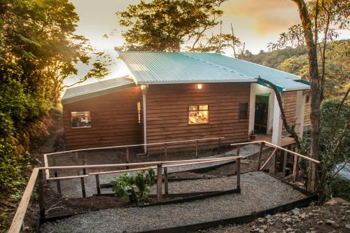 a small wooden cabin with a blue tin roof at Casa Por Fin in Monteverde Costa Rica