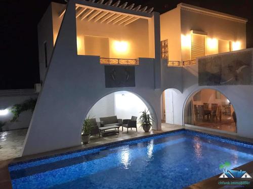a villa with a swimming pool at night at Villa Amine Flouka in Houmt Souk