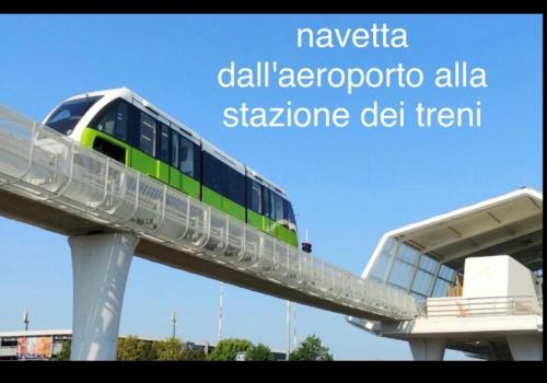a train on a bridge with the words navinia call aeroporto all at B&B La Fenice in Bologna
