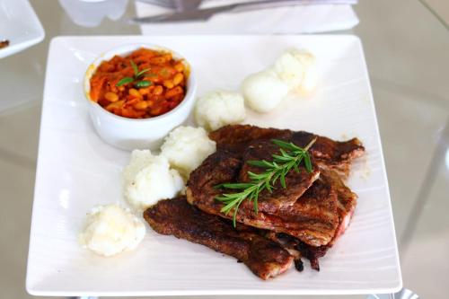 a plate of food with meat and vegetables on a table at Boeketlong Lodge in Jane Furse