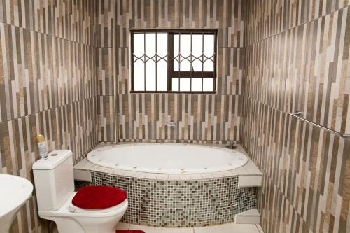 bagno con vasca, servizi igienici e finestra di Boeketlong Lodge a Jane Furse