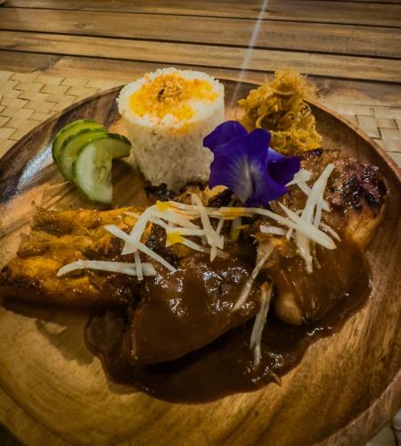 a plate of food with meat and rice on a table at Eco Sanctuaries Nature Lodge Nacpan Beach, El Nido in El Nido
