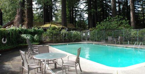 una piscina con mesa y sillas junto a ella en Miranda Gardens Resort, 