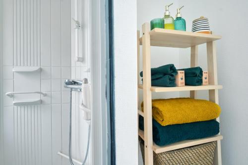 a bathroom with a shelf with towels and a shower at appartement cosy et charme au coeur de Besancon in Besançon