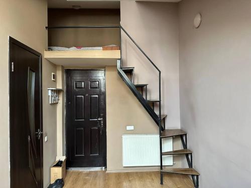 um corredor com uma escada e uma porta preta em Graz Narek house 4 em Altenfelden