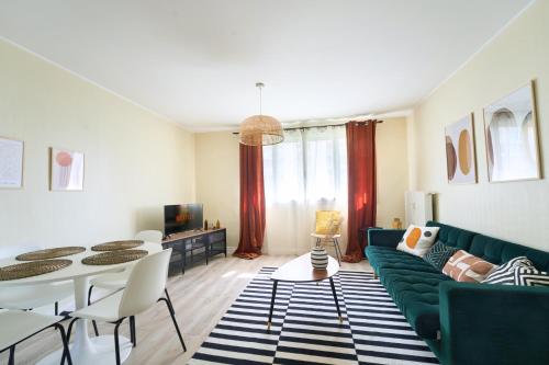 a living room with a green couch and a table at appartement cosy et charme au coeur de Besancon in Besançon
