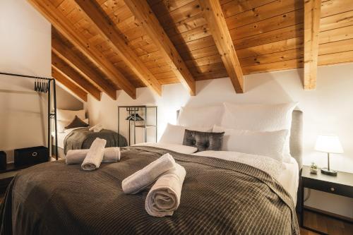 um quarto com uma cama grande e toalhas em ALPSTAY "Kuhstadl" - Maisonette, Gondelnähe & Netflix em Bad Kleinkirchheim