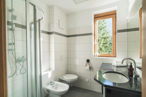 uma casa de banho branca com um lavatório e um WC em ALPSTAY "Kuhstadl" - Maisonette, Gondelnähe & Netflix em Bad Kleinkirchheim