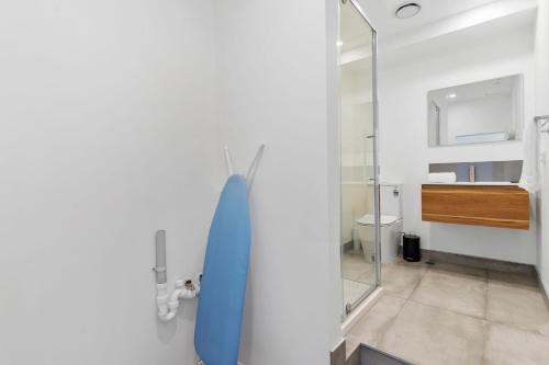 a bathroom with a blue surfboard hanging on a wall at Manukau Studio Apartments in Auckland