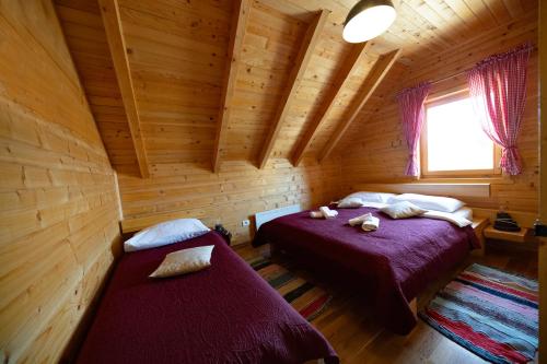 a bedroom with two beds in a log cabin at Riverside Apartments in Otočac