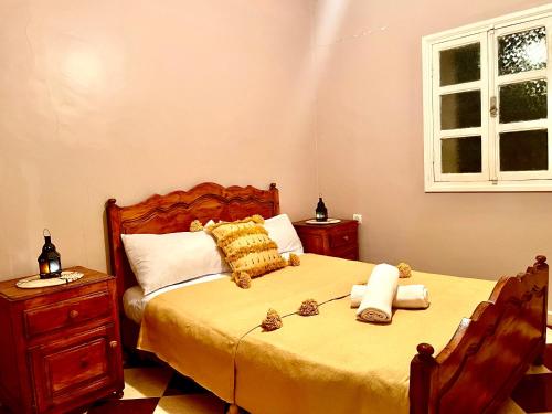 sypialnia z łóżkiem z żółtą pościelą i oknem w obiekcie Belle villa privé w mieście Ounara
