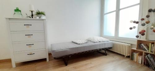 une chambre avec une commode et un banc dans l'établissement 100m2 d'espace et de calme au coeur de Montpellier, à Montpellier