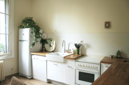 une cuisine avec un réfrigérateur blanc et un évier dans l'établissement 100m2 d'espace et de calme au coeur de Montpellier, à Montpellier