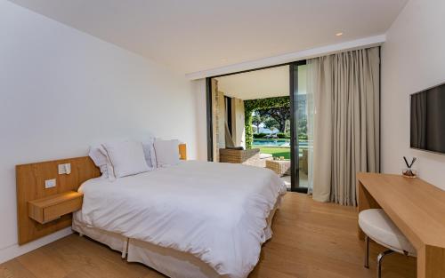 une chambre avec un lit, un bureau et une télévision dans l'établissement Villa Le Faune - Ultra-Luxurious 10 en-suites with Sea View and Tennis, à Saint-Tropez